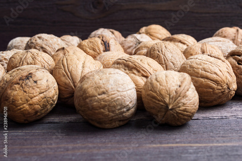 Many walnuts on a wooden background
