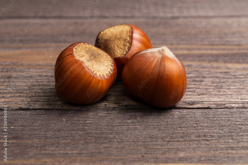 Obraz premium Several hazelnuts on a wooden background