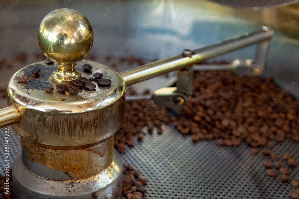 Traditional method of roasting dried organic arabica coffee beans in roster with open grid for cooling, bio coffee farm Traditional method of roasting dried organic arabica coffee beans in roster with open grid for cooling, bio coffee farm