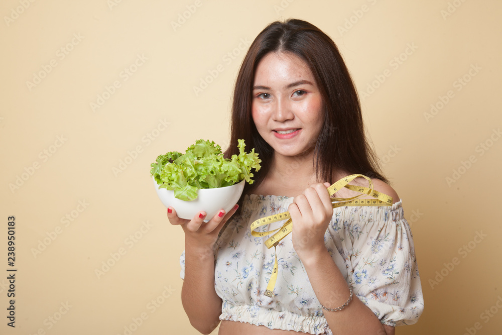 Healthy Asian woman with measuring tape and salad. Healthy Asian woman with measuring tape and salad.