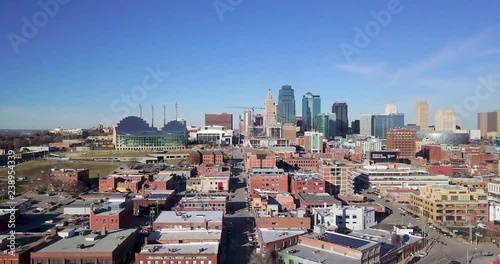 Aerial Shot over City Skyline Tilts Down Towards Neighborhood