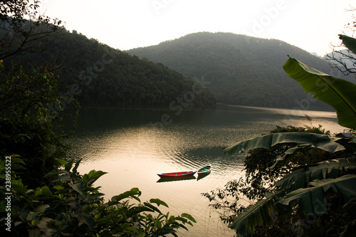 Boats around Phewa Lake and hills in Pokhara, a popular tourist destination. Taken in Nepal, December 2018. photo