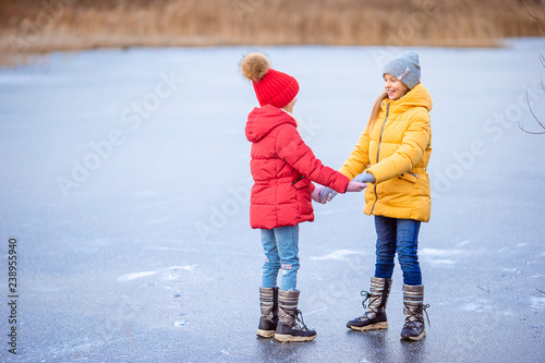 Adorable little girls skating on the ice-rink