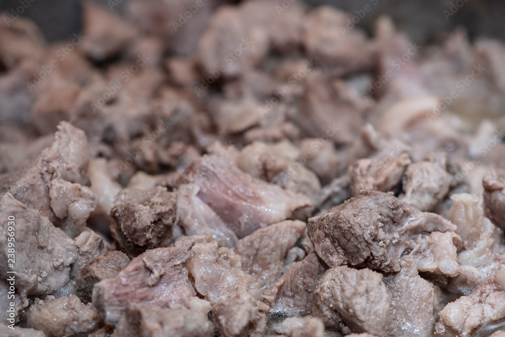 Preparation of home-made pork stew, cooking process in a pan, close-up. Ukrainian cuisine