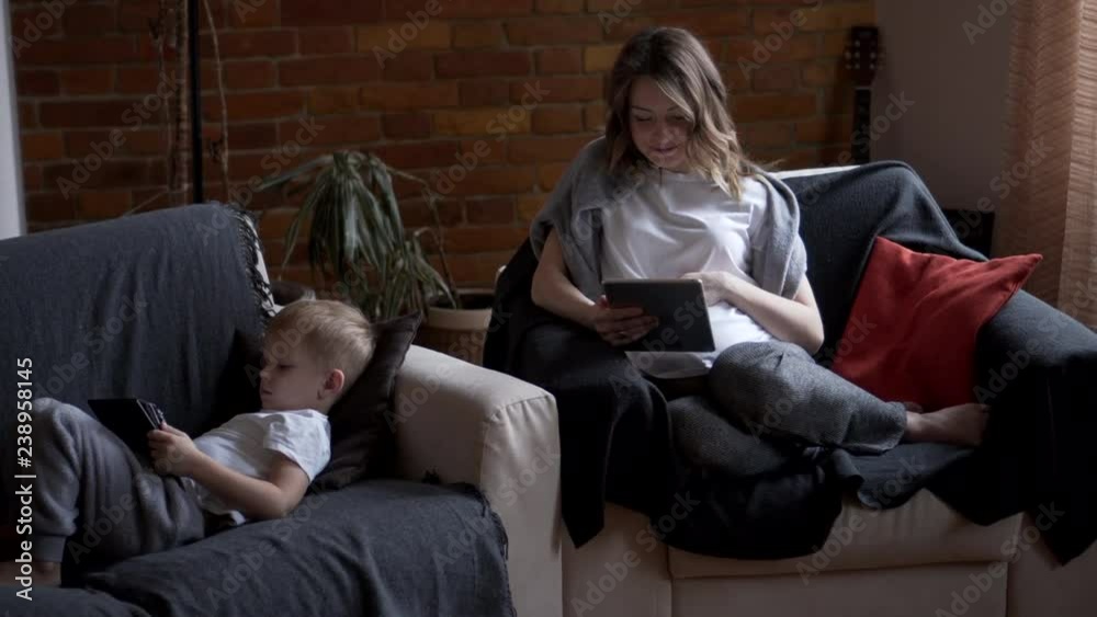 Pregnant mother and son using digital tablet at home Pregnant mother and son using digital tablet at home