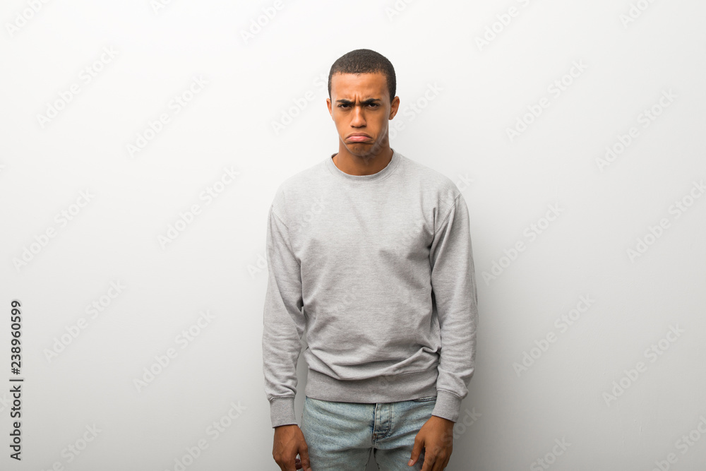 African american man on white wall background with sad and depressed expression African american man on white wall background with sad and depressed expression