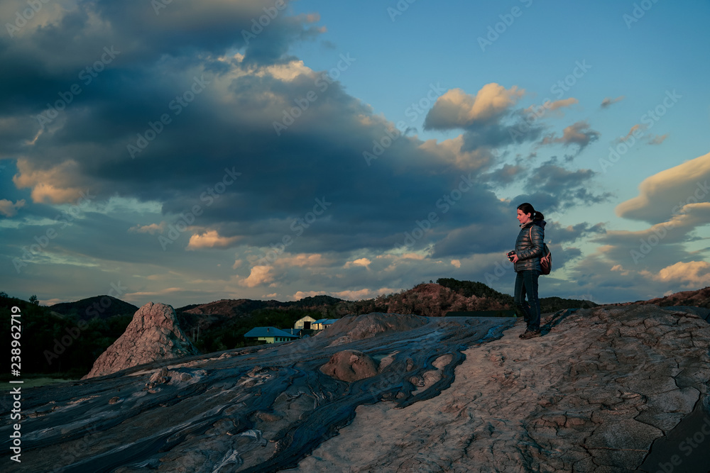 Fototapeta premium Woman visiting muddy volcanoes in Buzau, Romania