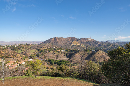 View of Hollywood Sign from Hollywood Hills. Warm sunny day. Beautiful clouds in blue sky.