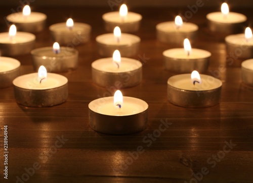 Blazing candles arranged in alignments on brown toned wooden table