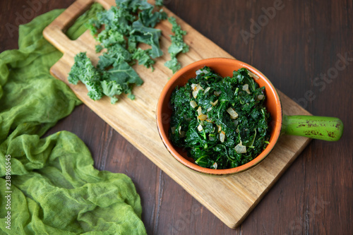 Foto Fresh Kale and Onions in Terra Cotta Bowl on Wooden Tabletop; Fresh Kale in back