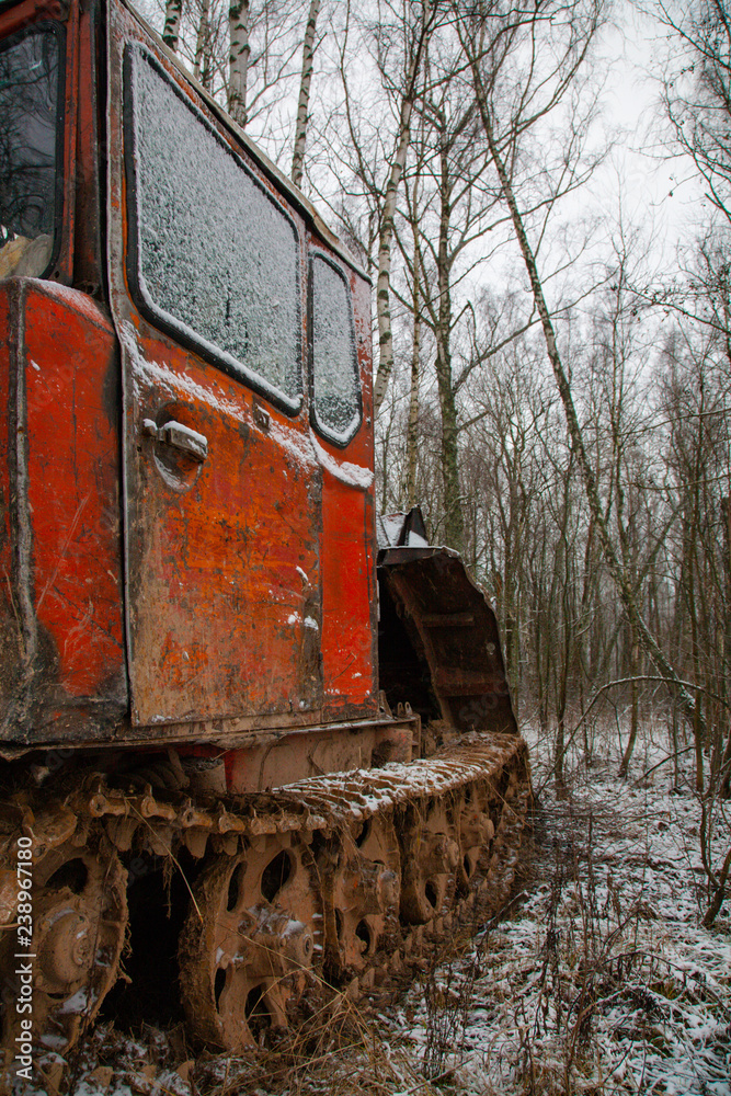 Rusty abandoned caterpillar snow tractor on winter surrounding, russia