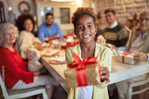 Smiling Cute girl giving x-mas present.