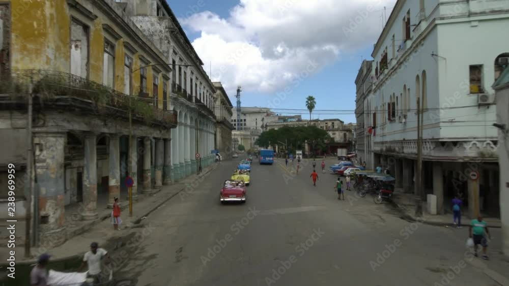 Drone aerial shot of row of classic 1950's American Vintage Convertible cars driving on street old Havana, Cuba Drone aerial shot of row of classic 1950's American Vintage Convertible cars driving on street old Havana, Cuba