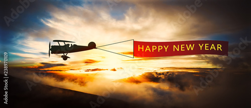 Foto old airplane with banner ' happy new year '