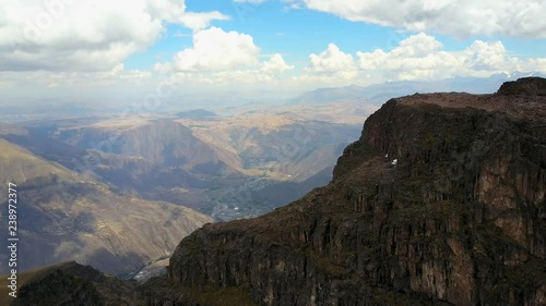 Aerial view of Epic Andean mountains, town, clouds. Reveal shot. photo