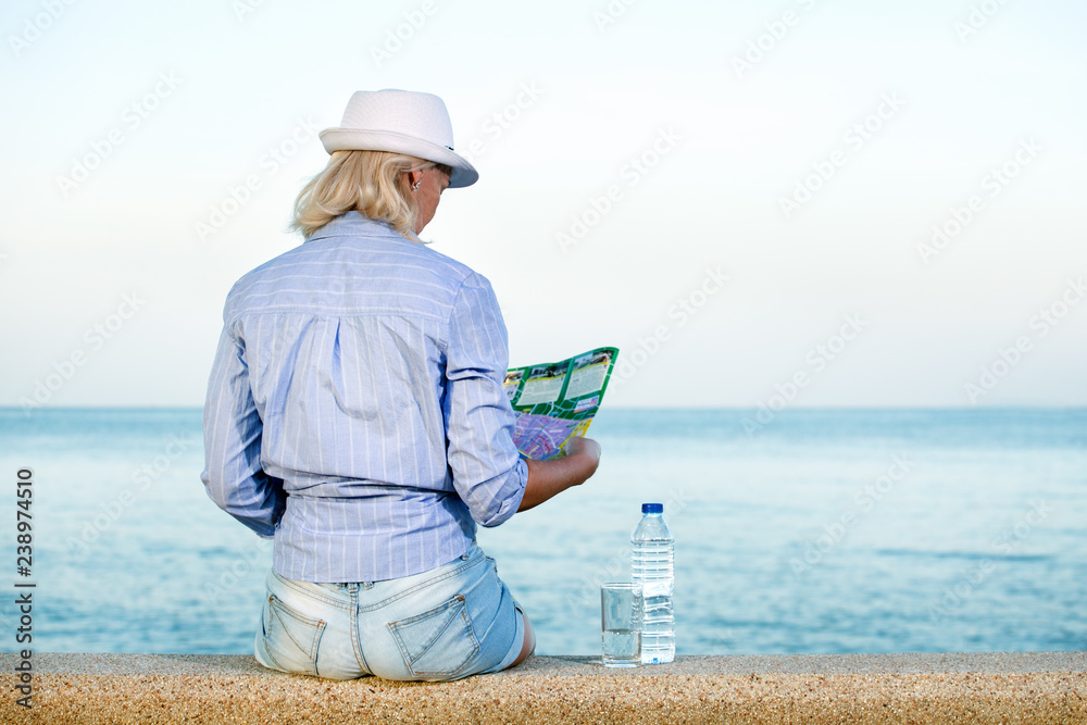 Traveller Woman With Map Looking Into Distance Stock Photo. Planning excursion.
