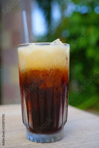 Glass of cold iced coffee with a straw