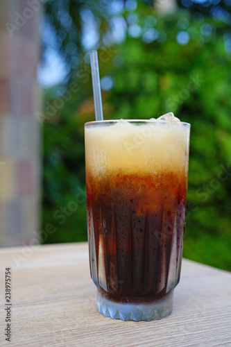 Glass of cold iced coffee with a straw