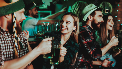 Man In Funny Hat Is Drinking Beer With A Girl.