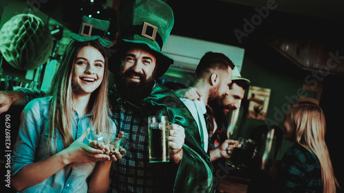 Man In Funny Hat Is Drinking Beer With A Girl.