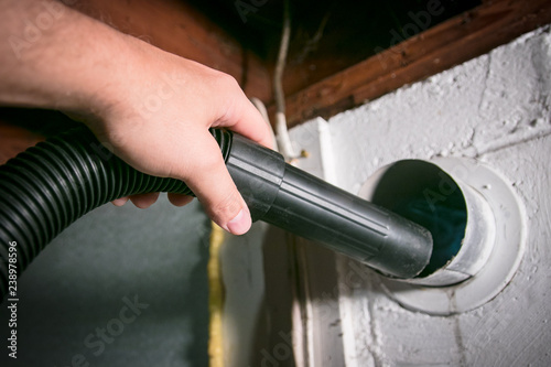 Vacuum cleaning a dryer exhaust vent, to remove lint and prevent fire hazard. photo