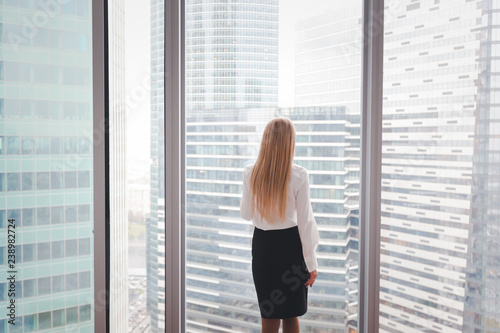 Young stylish beautiful blond business woman in a skyscraper in the office against the background of the window, the manager of the corporation business real estate, high floor photo
