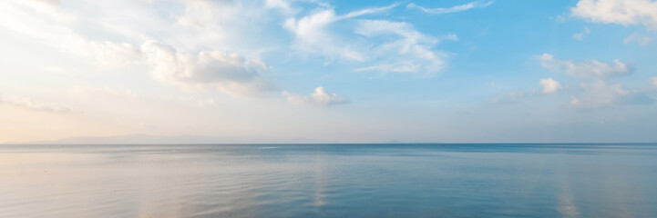 Bright beautiful seascape, sandy beach, clouds reflected in the water, natural minimalistic background and texture, panoramic view banner