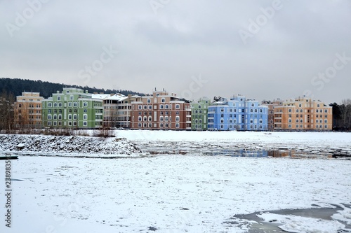 Разноцветные дома элитного жилья на берегу замерзающей бухты