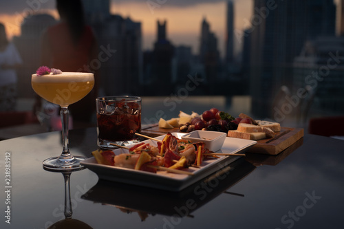 cocktails and food plate evening rooftop