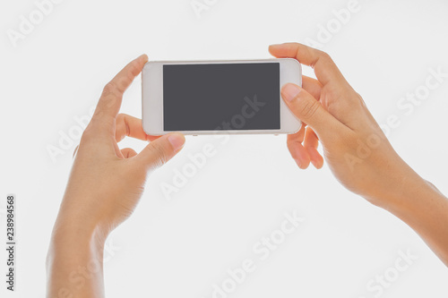 Woman typing on mobile phone isolated on black background.