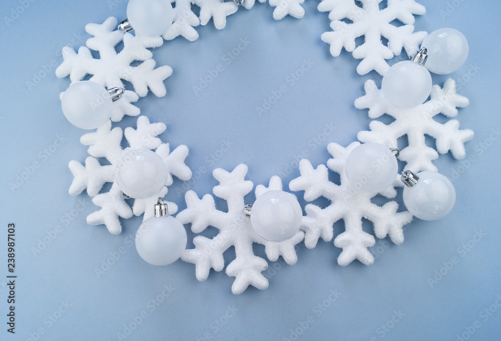 A wreath in a circle of decorative snowflakes on a blue background. A wreath in a circle of decorative snowflakes on a blue background.