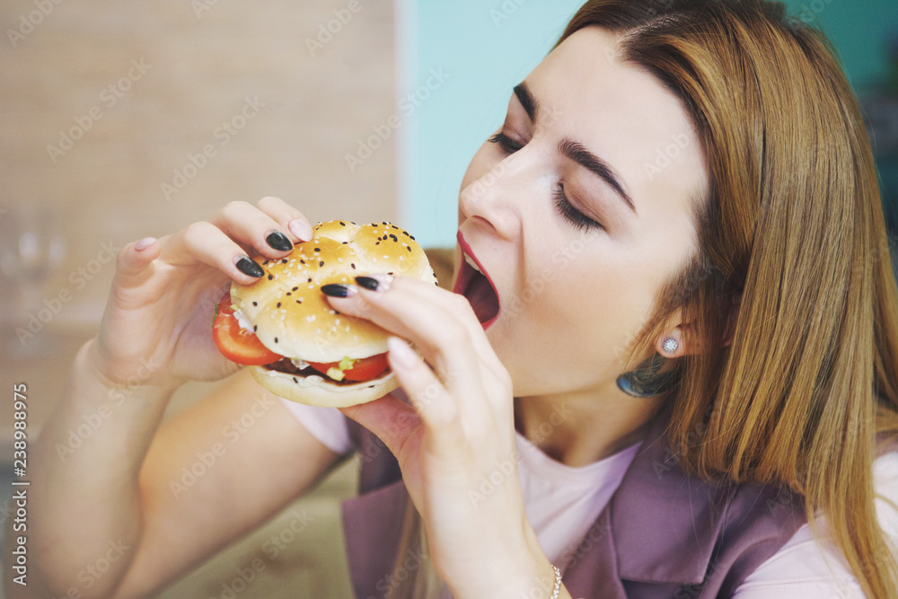 Pretty young woman with hamburger.