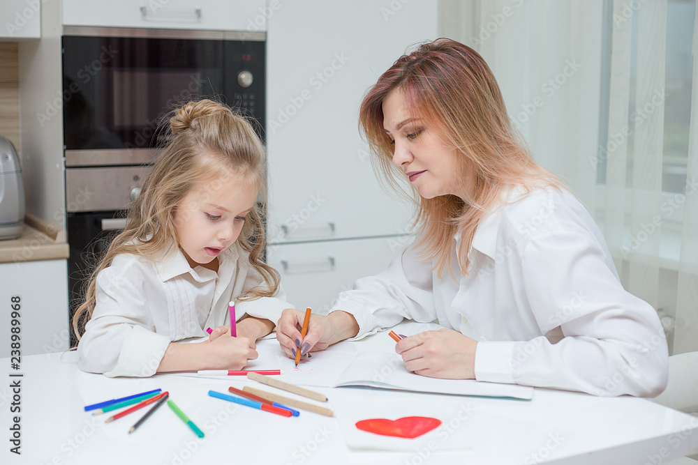 Mother and daughter are drawing together at home Mother and daughter are drawing together at home