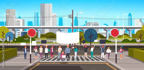 people crowd holding placard and megaphone on crosswalk modern city street skyscraper downtown road urban cityscape background protesting concept horizontal