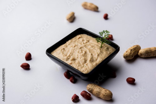 Healthy Peanut chutney made using Groundnut / Shengdana or mungfali. served in a small bowl with raw whole. Selective focus