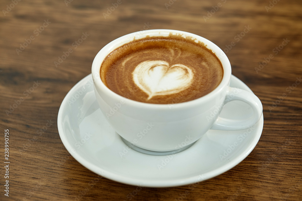 Obraz premium Cup of coffee with heart pattern