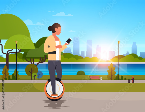 woman ride electric mono wheel using smartphone girl modern personal transport outdoor nature city urban park cityscape sunset background horizontal flat