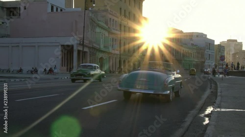 iconic classic 1950's American vintage convertible car driving on waterfront malecon street in old Havana, Cuba