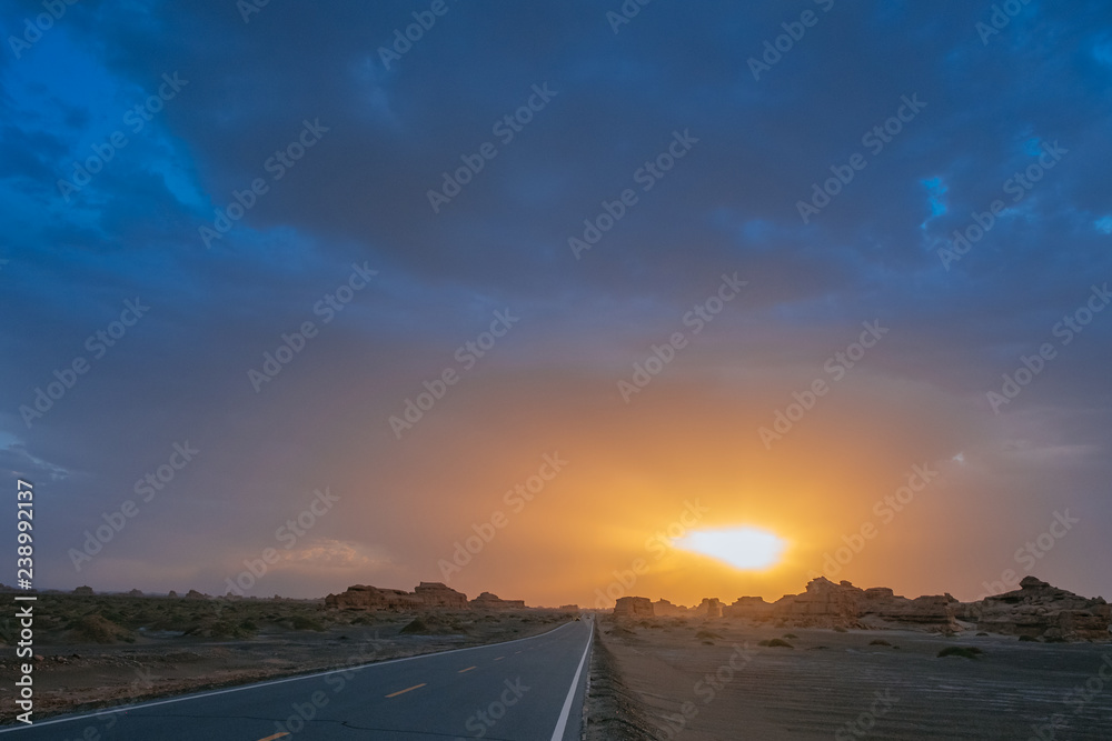 Car traveling on road in gobi desert at sunset in Dunhuang Yardang National Geopark, Gansu, China