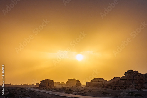 Car traveling on road in gobi desert at sunset in Dunhuang Yardang National Geopark, Gansu, China photo