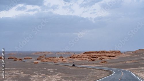 Car traveling on road in gobi desert at sunset in Dunhuang Yardang National Geopark, Gansu, China photo