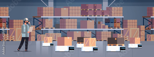 man engineer controlling robot car delivery product factory automation production concept modern warehouse room interior horizontal