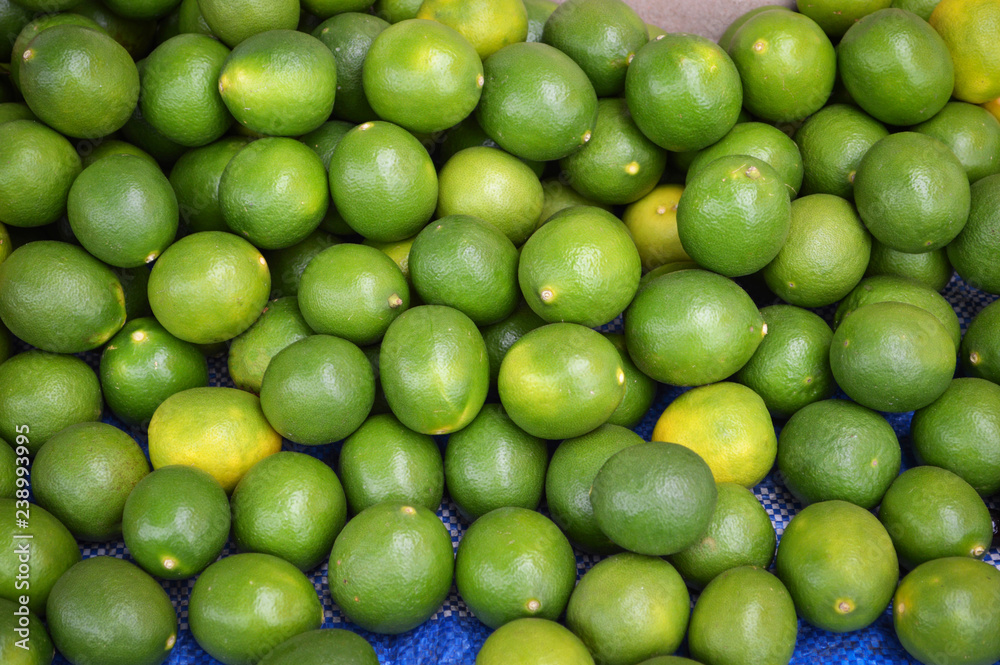 green fresh lemon lime texture background / pile of lime lemon for sale in the market