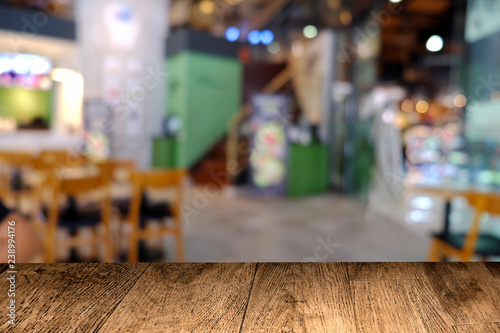 Wooden table in front of abstract bokeh background of cafe