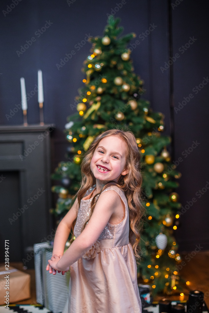 Little girl under the Christmas tree. A girl with gifts under the tree in anticipation of magic