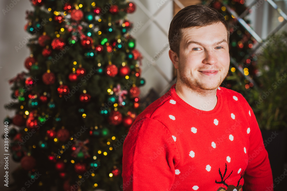Young plump guy at winter holiday, Christmas time, plus size man at cozy home Young plump guy at winter holiday, Christmas time, plus size man at cozy home