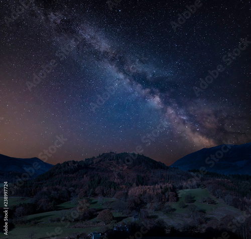 Stunning vibrant Milky Way composite image over Catbells near Derwentwater in the Lake District with vivid Fall colors all around the contryside scene