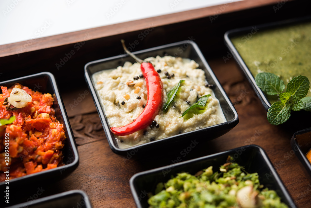 Group of Indian Chutneys includes coconut, Peanut, green and red chilly, garlic and pudina served in small square shape bowls. selective focus Group of Indian Chutneys includes coconut, Peanut, green and red chilly, garlic and pudina served in small square shape bowls. selective focus