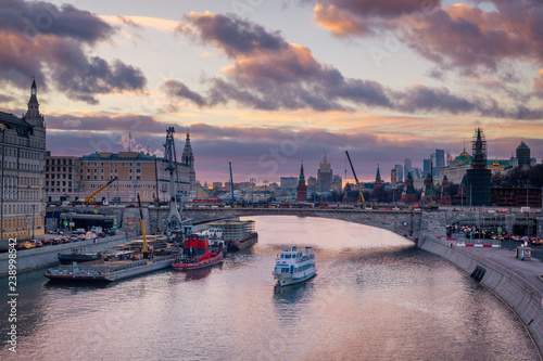 Beautiful purple sunset over Moskva river and a touristic boat cruising