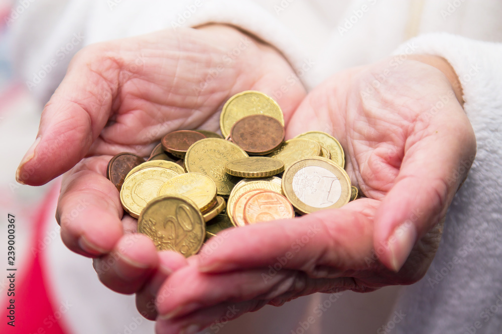 Pensioner man holding in hands euro coins, theme of low pensions. Pensioner man holding in hands euro coins, theme of low pensions.